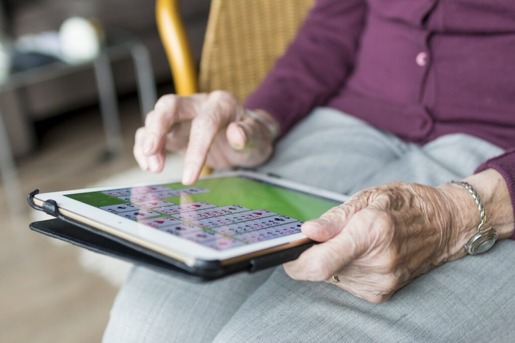 idoso jogando jogo eletrônico; pessoa idosa usando um tablet; estudo analisa influência da personalidade no envelhecimento de pessoas centenárias saudáveis